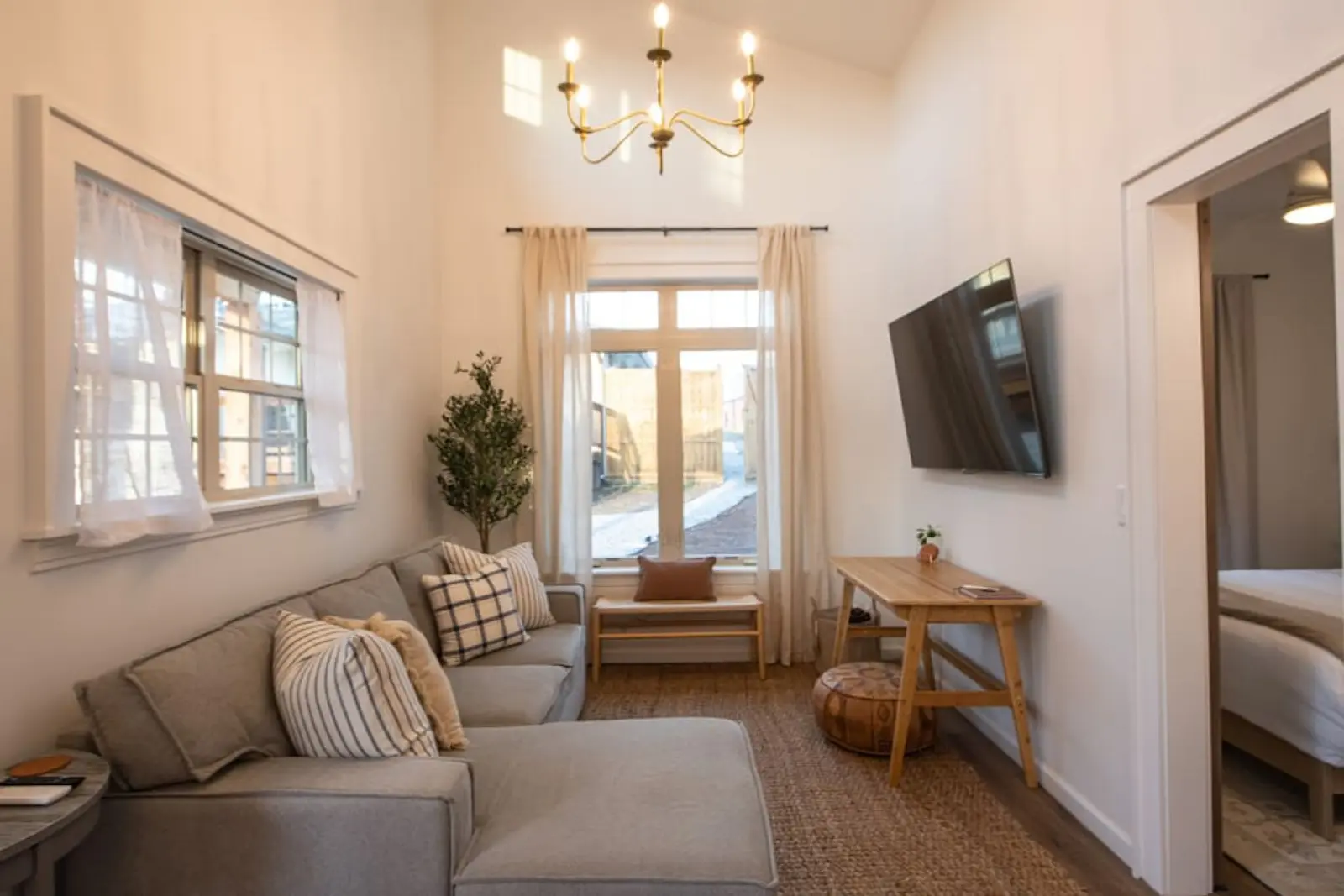 Cozy Cottage living room with high ceilings, chandelier and TV