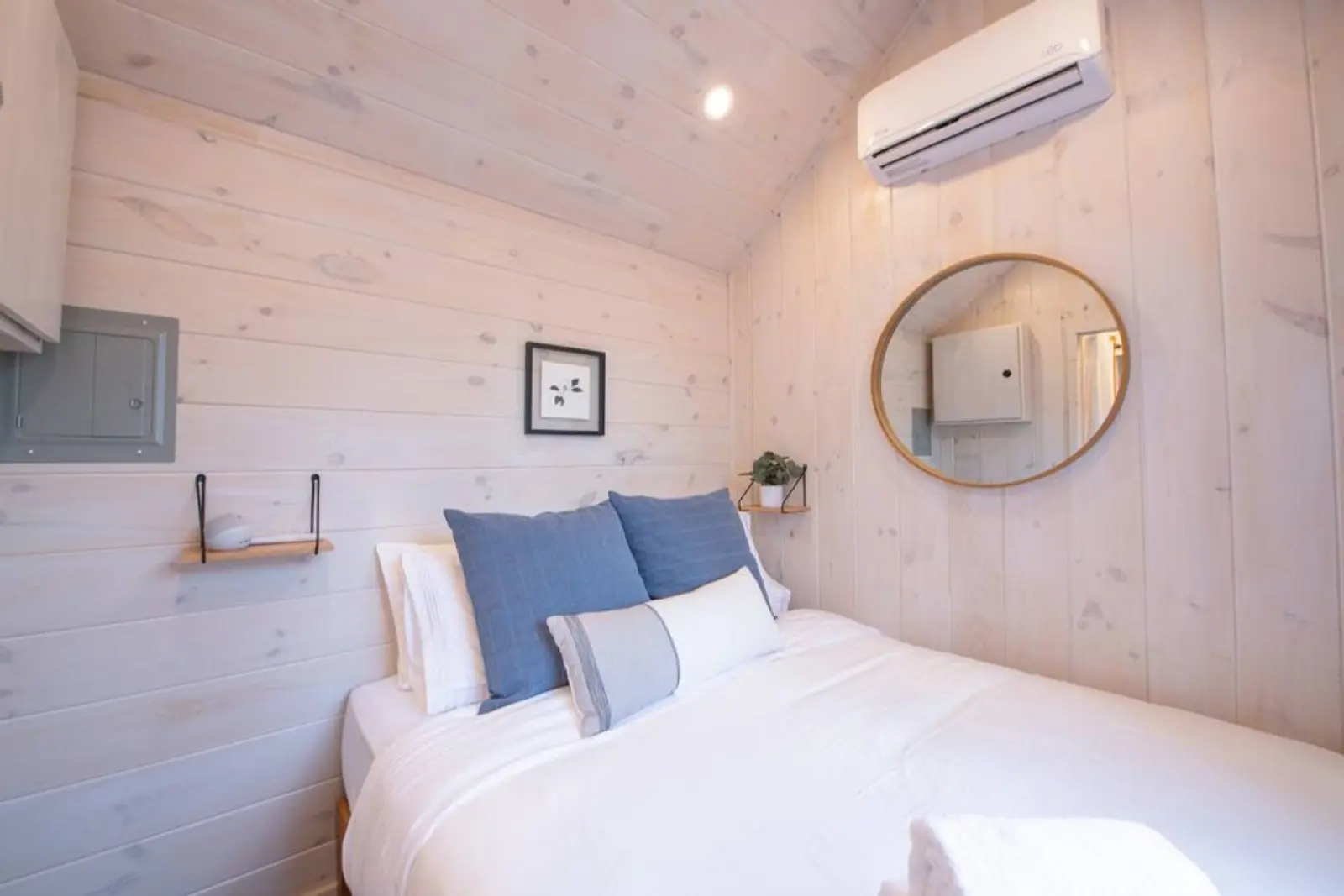 Magnolia Mini bedroom with a round mirror and mini-split